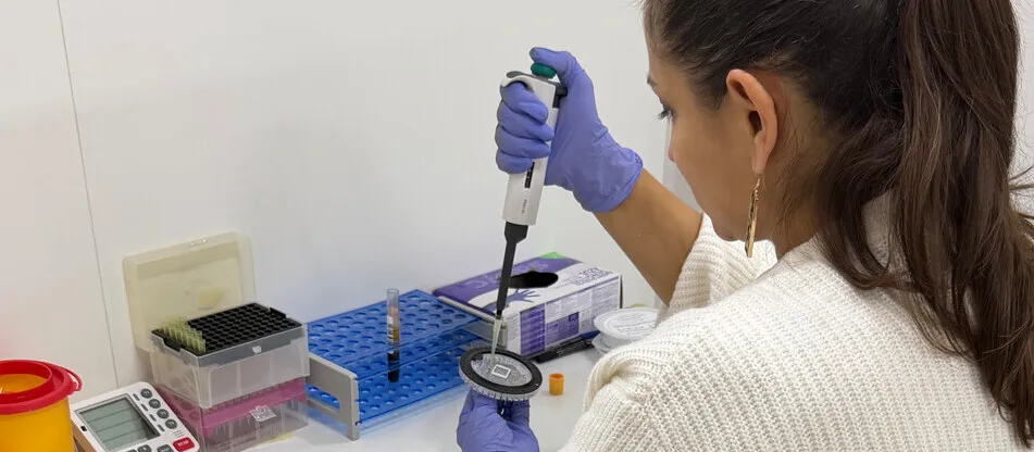 Professional del laboratori treballant amb una micropipeta.