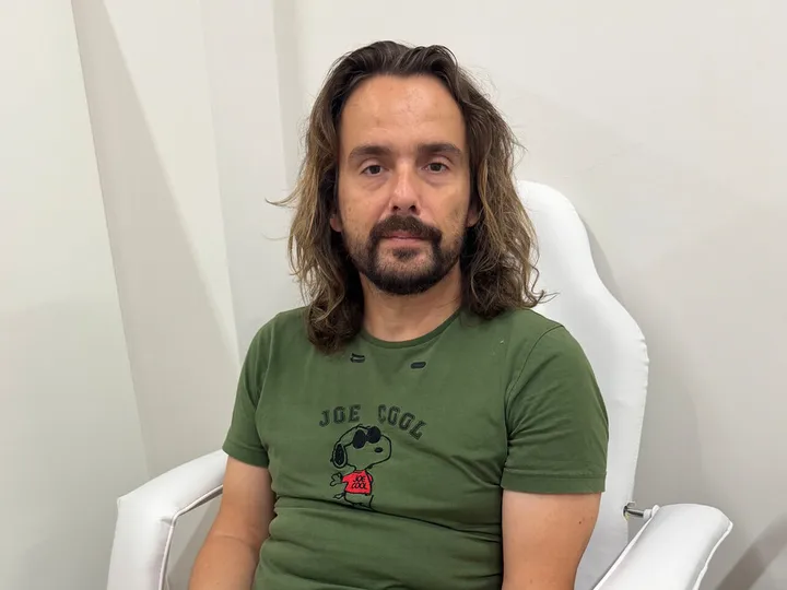 Participant de la sessió fotogràfica assegut en una butaca del laboratori.